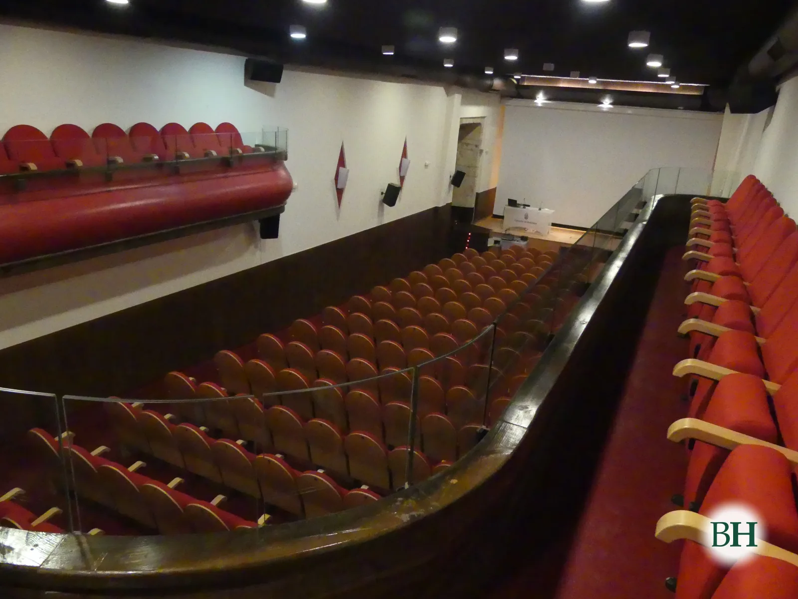La sala del Teatro Alfonsetti vista desde el anfiteatro: butacas rojas en el patio y en los palcos laterales.