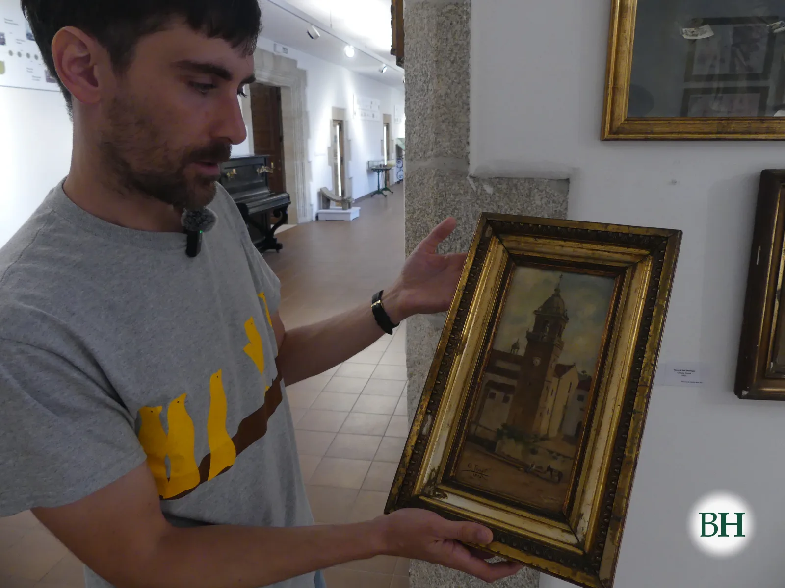 Ángel, director do Museo das Mariñas, coa pintura de Olimpia Tourné que mostra a igrexa de Santo Domingo na Praza do Campo.
