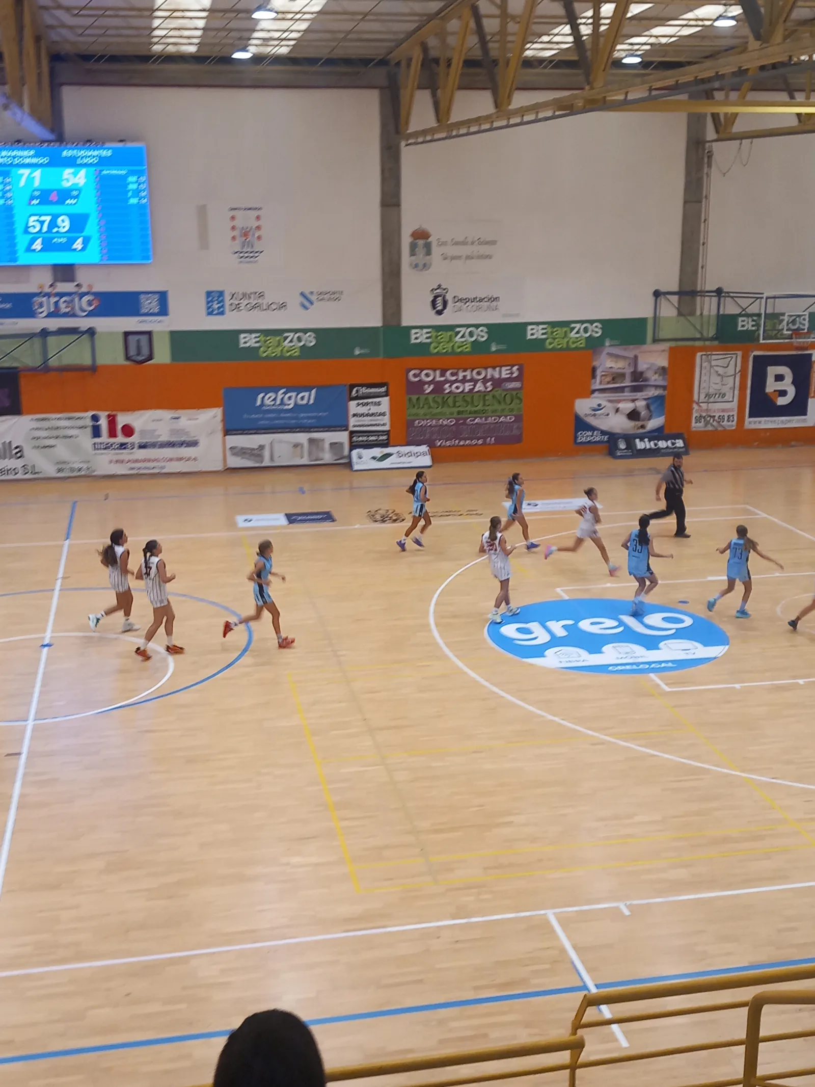 El marcador del pabellón en el último cuarto: Warnier Santo Domingo 71, Estudiantes Lugo 54, con el juego en marcha en la pista.