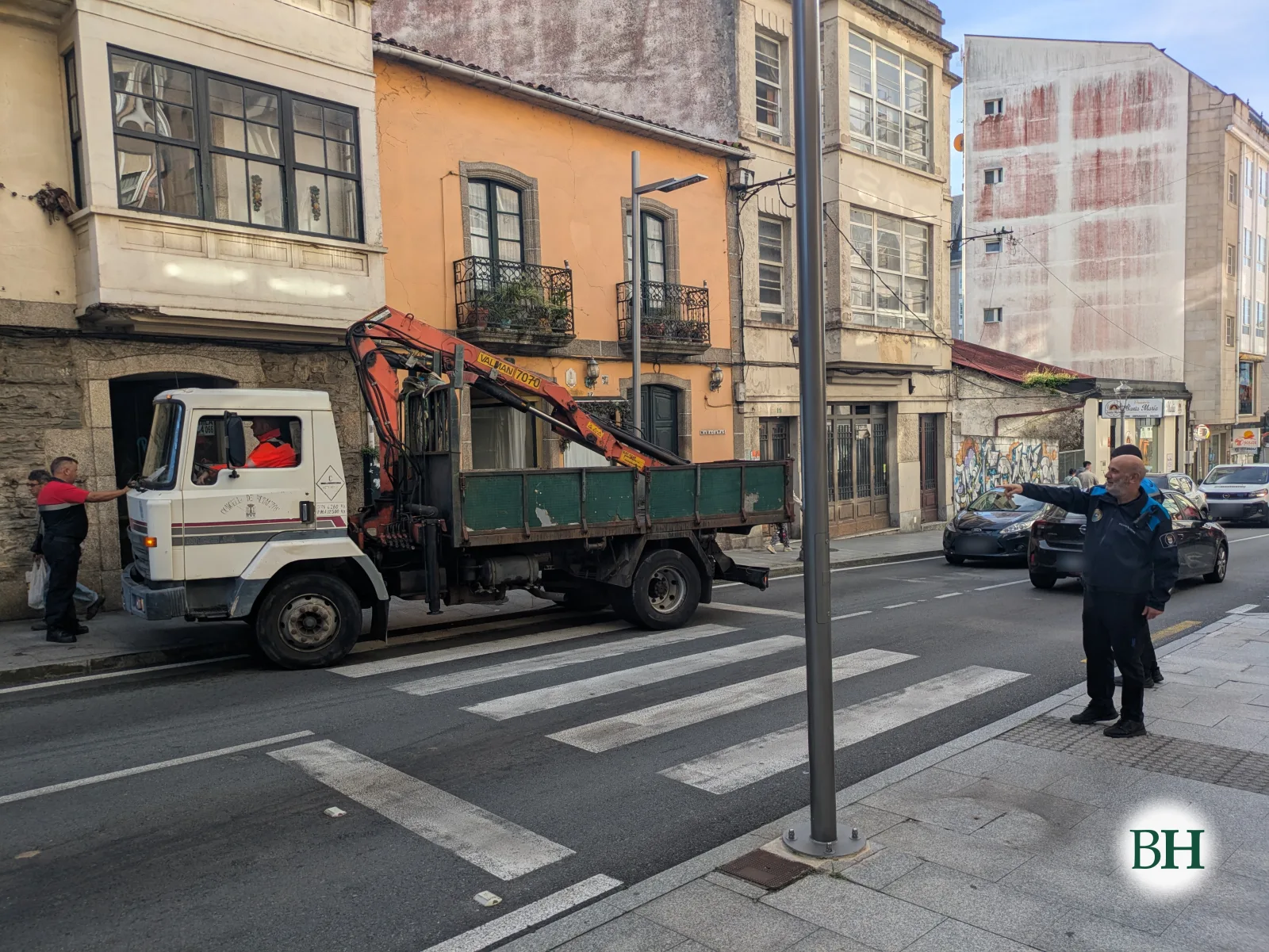 Un camión grúa do Concello de Betanzos xunto ao paso de peóns da avenida de Jesús García Naveira mentres un axente da Policía Local regula o tráfico.