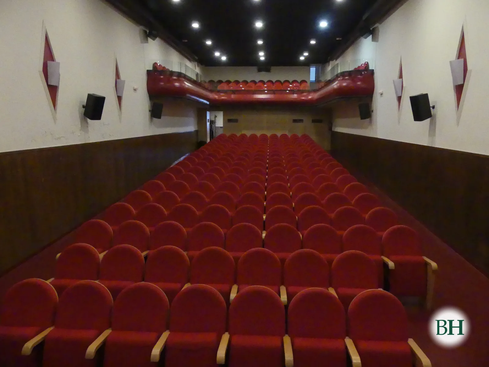 El patio de butacas rojas del Teatro Alfonsetti visto desde el escenario, con el anfiteatro al fondo.